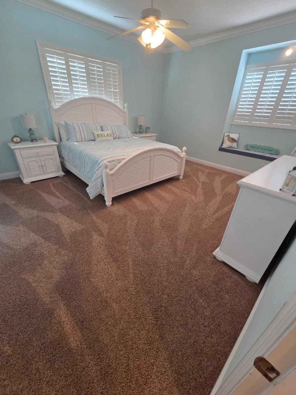 Condo bedroom with fresh carpet lines, made up for guest arrival